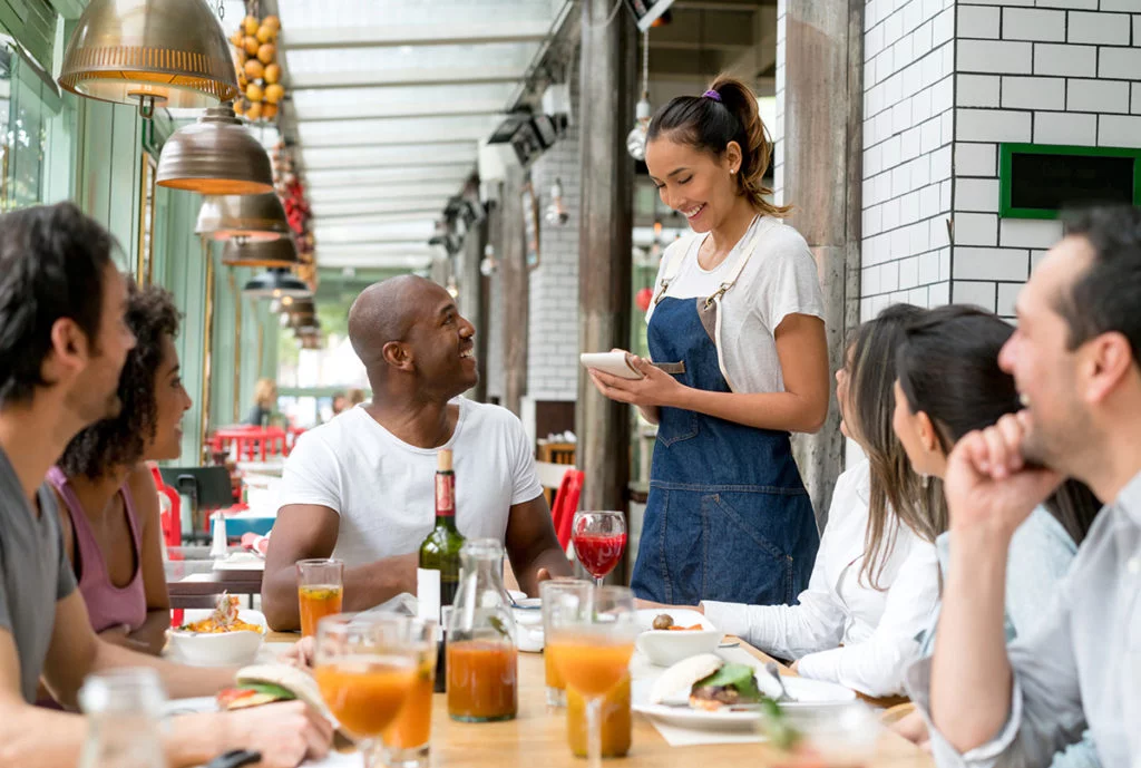 Waitress taking orders to people at a restaurant
